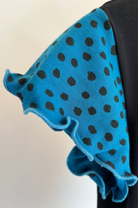 Blue fabric with black polka dots on a white background