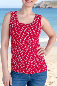 Woman wearing a red tank top with white patterns on a beach