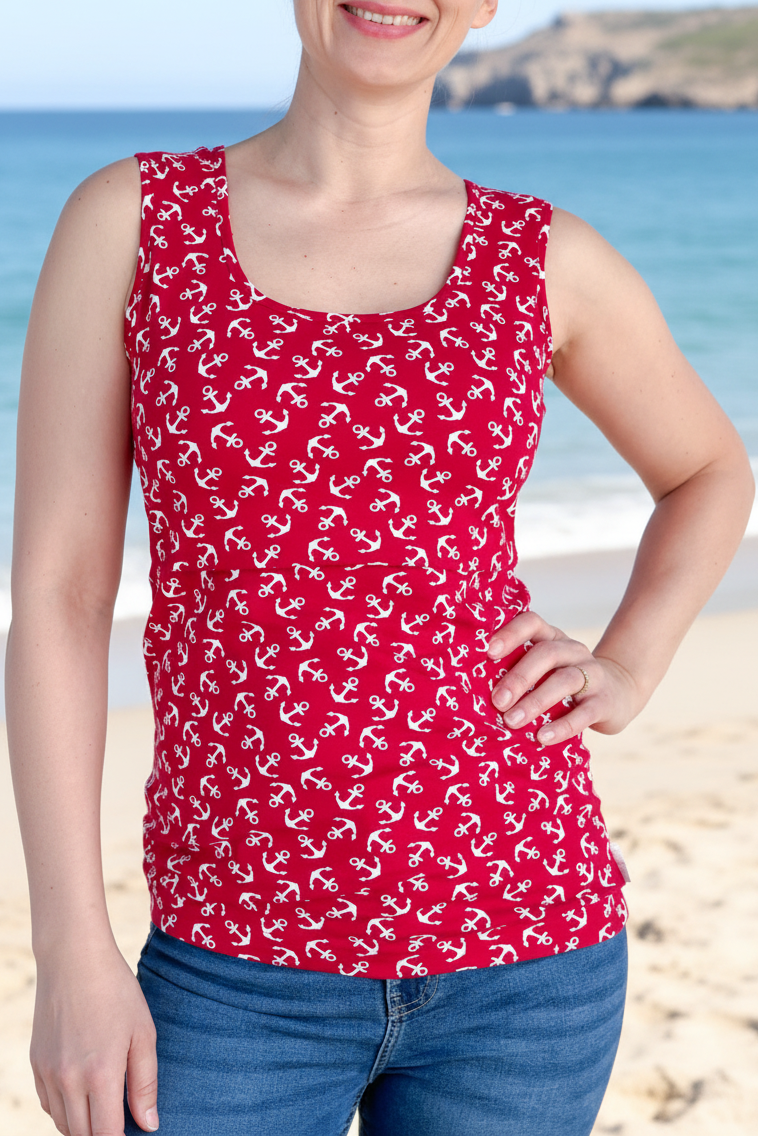 Woman wearing a red tank top with white patterns on a beach